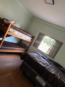 Un dormitorio con una litera y una ventana. en Casa na represa do broa, en Campo Alegre