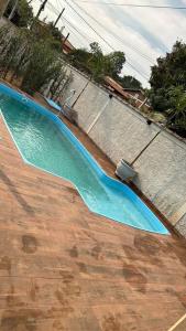 Una piscina con agua azul en un patio. en Casa na represa do broa, en Campo Alegre