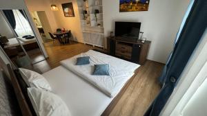a bedroom with a white bed with two blue pillows at DD Studio Deluxe in Sibiu