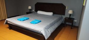 a bedroom with a bed with two blue pillows on it at Le Noci in Ao Nang Beach