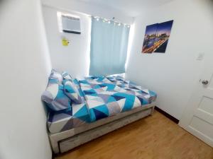 a bedroom with a bed in a white room at Arezzo Place Davao - Condo Rentals WITH FREE POOL, 200MBPS CONNECTION in Lanang