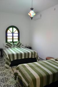 1 dormitorio con 2 camas con rayas verdes y blancas en Riad Aïcha Addi - Poolside - Traditional Moroccan, en Essaouira 30 fotos más