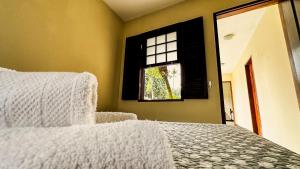 a bedroom with a bed and a window at Pousada Villa Aman in Paraty