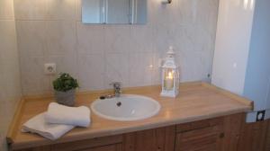 a bathroom counter with a sink and a candle on it at Gästehaus Zur Linde in Otterndorf +80 photos