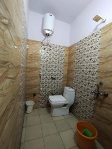 a bathroom with a toilet and a wall at Milestone Homestay Agra in Tājganj +25 photos