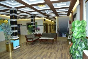 a lobby with chairs and a table in a building at Kings Hotel in Sargodha