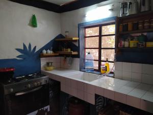 a kitchen with a sink and a stove and a window at Chez Yaya, chambre bleue in Oussouye +15 photos