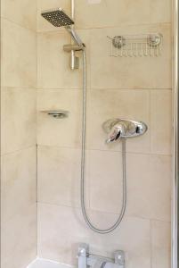 a shower with a shower head in a bathroom at LITTLE FRANCE House room2 in Edinburgh