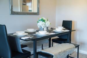 カンタベリーにあるTrendy Central Apartment with Free Parking - Perfect for Contractors and Familiesの黒いダイニングテーブル(椅子、鏡付)