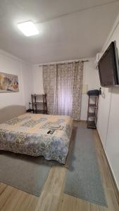 a bedroom with a bed and a flat screen tv at Cantinho da Casa in Avis