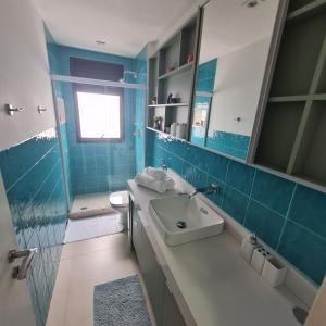 a blue bathroom with a sink and a toilet at Apto frente praia-AlfaPark-Barra da Tijuca in Rio de Janeiro