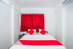 a bedroom with a red curtain and a bed at Royal Guest inn HSR Layout in Bangalore