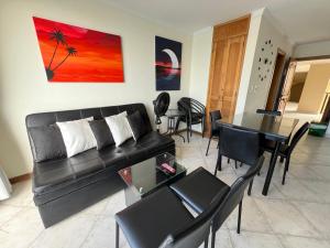 a living room with a black couch and a table at El Peñon del Rodadero - Apto 1303A in Santa Marta