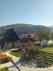 una casa con techo negro y valla en Apartmani Gocki Raj 2024 Vrnjačka Banja, en Vrnjačka Banja
