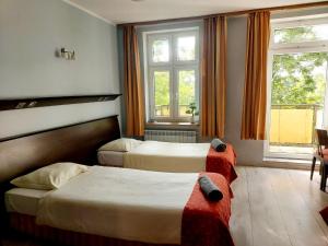 pokój hotelowy z 2 łóżkami i 2 oknami w obiekcie GLIWICKA 16 w mieście Katowice