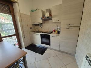 a kitchen with white cabinets and a stove at Appia Antica Apartment in Rome +5 photos