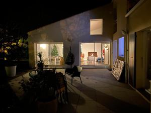 a night view of a house with a patio at Maison familiale LA ROCHELLE in LʼHoumeau