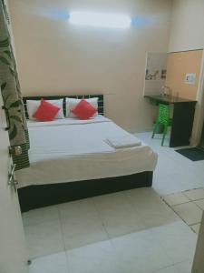a bedroom with a bed with red pillows on it at Royal Guest inn HSR Layout in Bangalore