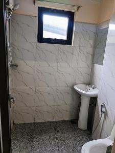 a bathroom with a white sink and a window at The Touch Affordable Baguio Apt in Baguio +16 photos