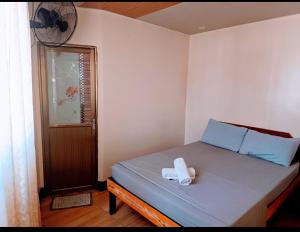 a small bedroom with a bed with a white object on it at The Touch Affordable Baguio Apt in Baguio