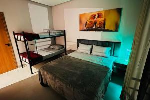 a bedroom with a bed and a bunk bed at COC00N HOUSE - Vale do Capão in Palmeiras