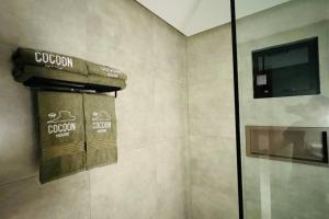 a bathroom with a towel dispenser on a wall at COC00N HOUSE - Vale do Capão in Palmeiras +25 photos