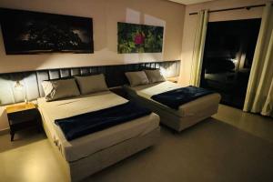 a bedroom with a bed and a couch and a bed and a chair at COC00N HOUSE - Vale do Capão in Palmeiras
