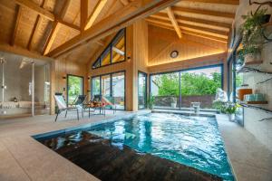 an indoor swimming pool in a house with wooden ceilings at Chalet Soleil Bœuf et Spa de l'adouss in Saint-Jean-Saint-Nicolas