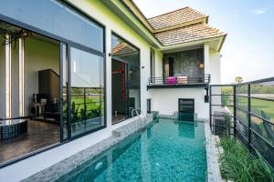 an indoor swimming pool in a house with glass windows at THANN Wellness Destination in Phra Nakhon Si Ayutthaya +32 photos