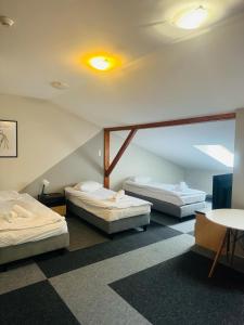 a room with three beds and a table at Magiczna Farma Hotel Obiady Mąka i Magia in Zambrów