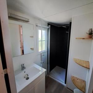 a white bathroom with a sink and a shower at Sable d'or in Le Grau-dʼAgde
