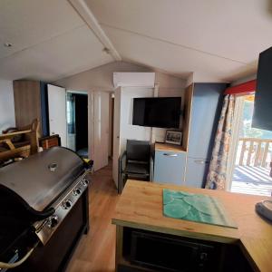 a kitchen with a stove and a living room at Sable d'or in Le Grau-dʼAgde