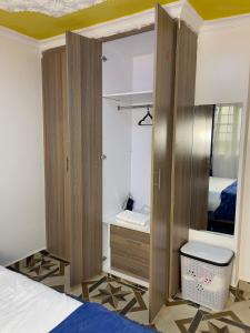 a bedroom with a bed and a wooden closet at Rukiya's Haven in Nairobi