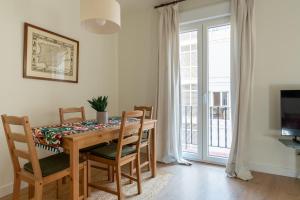 a dining room with a table and chairs and a window at Sweet Home Santander in Santander