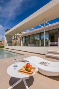 einen Tisch mit zwei Weingläsern und einer Obstschale in der Unterkunft LIMA 18 , Las Colinas Golf, Orihuela costa in Orihuela