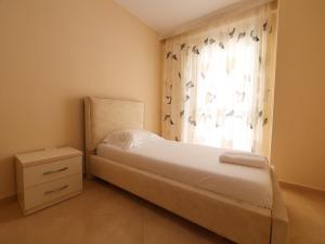 a small bedroom with a bed and a window at Sea View Apartments in Durrës
