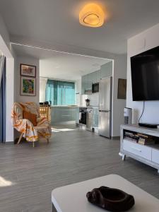 a living room with a television and a kitchen at Penthouse Giner Benidorm centro playa by TRG in Benidorm
