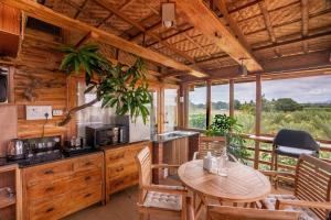 een keuken met een tafel en stoelen in een hut bij Habba Dates Villa Near Chikkaballapur in Bāgepalli