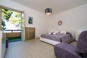 sypialnia z łóżkiem i przesuwanymi szklanymi drzwiami w obiekcie Villa Agave - SeaFront - Pool Kids - BBQ w mieście Santa Flavia