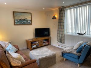 ein Wohnzimmer mit Couch und Fernseher in der Unterkunft Hope Corner in Filey