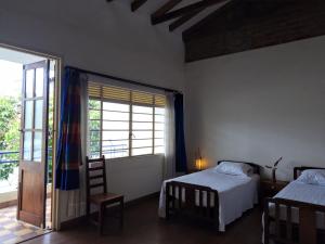 a bedroom with two beds and a large window at Heliconia in Cali
