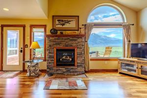 a living room with a fireplace and a large window at Yellowstone Trail Lodge in Emigrant