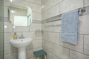 a white bathroom with a sink and a mirror at St Lucia Heights in St Lucia +26 photos