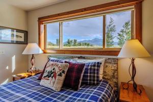 a bedroom with a bed with two lamps and a window at Mountain Sanctuary in Livingston