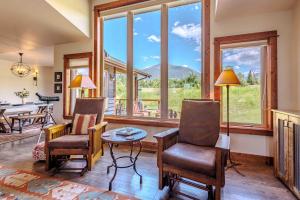 a living room with chairs and a table and windows at Mountain Sanctuary in Livingston