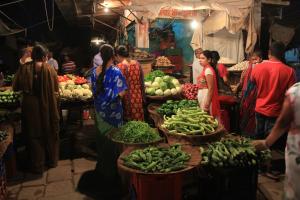 a group of people in a market with fruits and vegetables at Tanu's homestay in Jodhpur