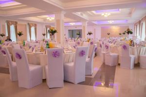 布拉日的住宿－拉維旅館，宴会厅配有白色的桌子和白色的椅子