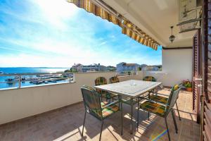 a patio with a table and chairs on a balcony at Apartman Ivka A1 in Petrcane