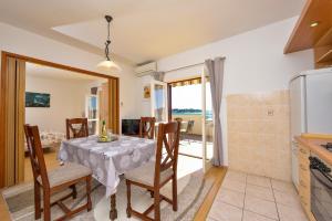 a kitchen and dining room with a table and chairs at Apartman Ivka A1 in Petrcane +9 photos