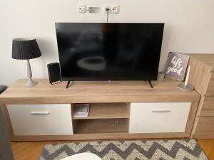 un téléviseur à écran plat posé sur un centre de divertissement en bois dans l'établissement Kawalerka, à Żyrardów
